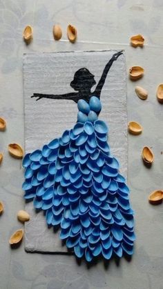 a piece of art made out of paper with shells around it and a drawing of a woman in a blue dress