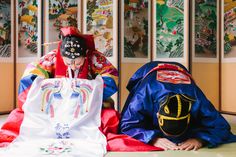 two people dressed in traditional japanese clothing sitting on the floor next to each other,