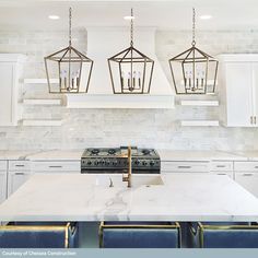 a kitchen with marble counter tops and blue chairs in front of an island that has four lights hanging over it