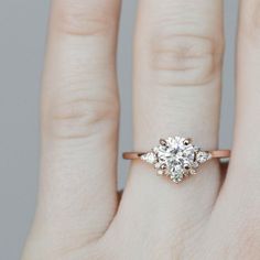 a woman's hand with a diamond ring on her left hand and an engagement band