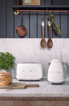 two toasters sitting on top of a kitchen counter next to a loaf of bread