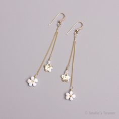 "These delicate, dangling flower earrings are made with hammered 14k bright gold filled flower pendants; Japanese drop beads in opaque white rainbow finish and with tiny 24k gold plated Japanese Delica beads, woven in the center of each beaded flower. The flowers are attached by wrapped gold filled wire to a delicate 14k gold filled 0.9mm chain. The chains are attached to 14k gold filled ear hooks with 2mm ball.  Measurements: The whole dangling part is 2.5\" (6.35 cm) long. The beadwoven flower is 9 mm in diameter.  The gold flower is 7mm in diameter. S-106/35skl" Fringe Flower, Beaded Daisy, Small Charms, Delica Beads, Drop Beads, Dangling Earrings, Gold Texture, White Beads, Gold Flowers