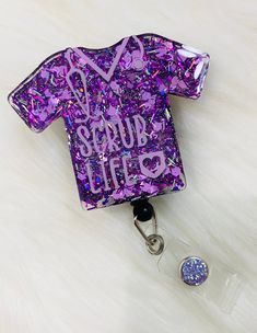 *this glittered scrub life badge reel comes attached to a black retractable badge reel with a clip  *they measure approximately 2in tall & 2.5in wide (sleeve to sleeve)  *this badge reel comes in a purple glitter mix with a light purple jewel & light purple vinyl   (as pictured)  *please see other listings for different color combinations. *if you don't see what you're looking for, please message me Personalized Purple Badge Reel As Gift, Personalized Purple Badge Reel For Gift, Personalized Purple Badge Reel Gift, Affordable Personalized Purple Badge Reel, Cheap Retractable Multicolor Badge Reel, Adjustable Multicolor Retractable Badge Reel, Multicolor Retractable Badge Reel, Scrub Life, Pink Personalized Novelty Badge Reel