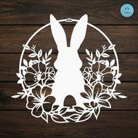 the silhouette of a rabbit is surrounded by flowers and leaves on a wooden background with a blue sticker