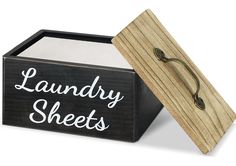 a wooden box with laundry sheets written on the front and bottom, sitting next to a pair of scissors