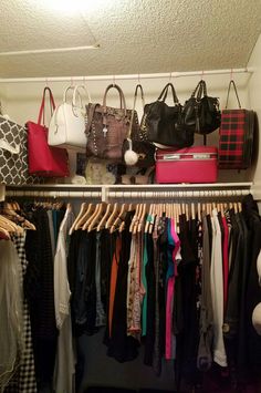 an organized closet with handbags and purses hanging on the rail, clothes hangers below