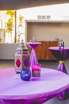 a table with purple cloth on it and two vases