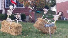 two skeletons sitting on hay bales in front of a house