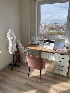 a room with a desk, chair and large window overlooking the city below in front of it