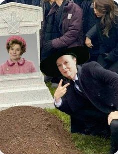 a man kneeling in front of a grave with a woman's face on it