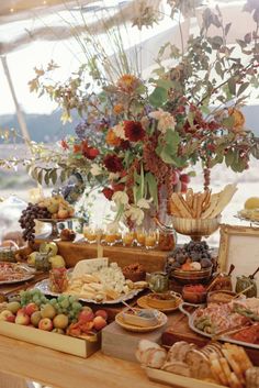 a table filled with lots of food on top of a wooden table covered in flowers