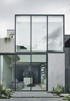 a modern house with large glass windows on the outside