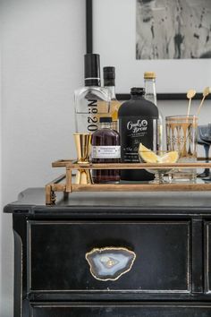 an old dresser has liquor bottles and glasses on it, along with other items from the bar