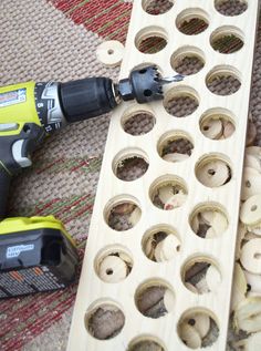 a drill and screwdriver sitting on top of a piece of wood with holes in it