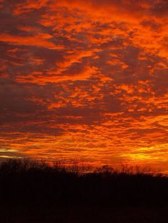 an orange and red sunset with clouds in the sky