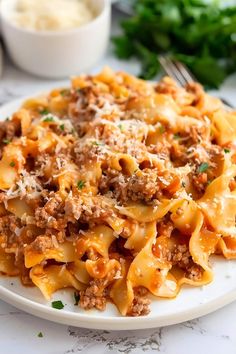 a white plate topped with pasta and meat