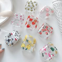 several small glass containers with fruit designs on them and a fork in front of the container