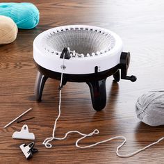 a ball of yarn sits on the floor next to a crochet hook and an iron