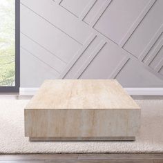 a square wooden table sitting on top of a white rug