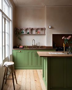 a kitchen with green cabinets and wooden floors