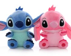 two small stuffed animals sitting next to each other on a white surface and one is pink and the other is blue