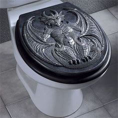 a black and white photo of a toilet with an intricate design on the tank lid