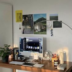 a desktop computer sitting on top of a wooden desk next to a lamp and other items