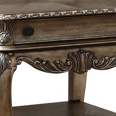 a wooden table with an ornate design on the top and bottom shelf, along with a drawer