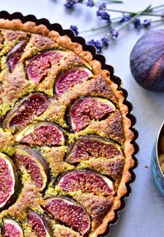 a pie with figs and other fruits on the table