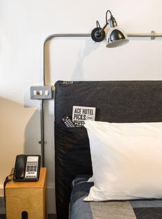 a bed with two pillows and a phone on the nightstand