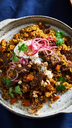 a white bowl filled with food on top of a blue table cloth