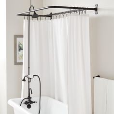 a bath tub sitting next to a white shower curtain