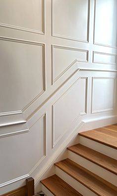 an empty room with white walls and wooden stairs