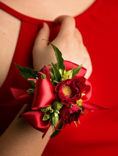 a woman wearing a red dress holding a bouquet of flowers