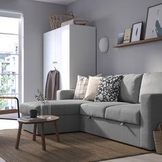 a living room with a gray couch and wooden coffee table in front of a window