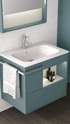 a bathroom sink sitting under a mirror next to a cabinet