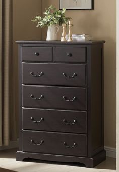 a black dresser with drawers and vases on top