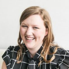 a woman sitting on a couch smiling at the camera