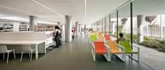 the interior of a library with people standing and sitting