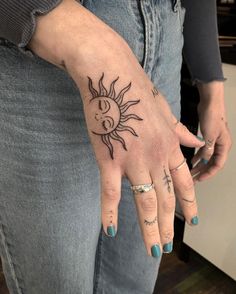 a woman's hand with a sun tattoo on it