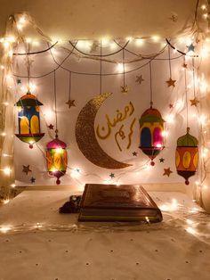 a decorated room with lights and lanterns on the wall, in arabic writing that reads eid