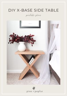 a small table with a vase on it next to a bed