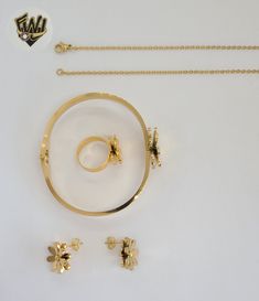 three pieces of gold jewelry on a white surface