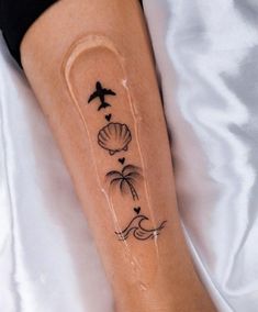 a person with a tattoo on their leg that has shells and birds flying over them