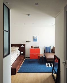 an open door leading to a bedroom with two beds and a desk in the corner