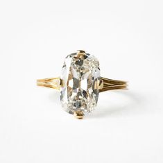 an old cut diamond ring with two tone gold band, set on a white background