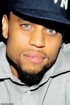 a close up of a person wearing a hat and looking at the camera with an intense look on his face