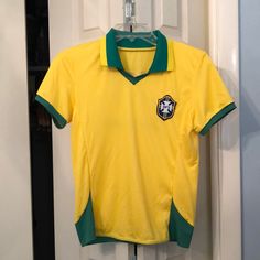 a yellow and green soccer shirt hanging on a door hanger in front of a white door