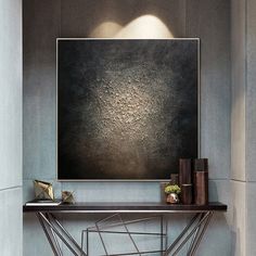 an abstract painting hangs on the wall above a console table with books and vases