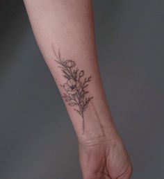 a small flower tattoo on the wrist